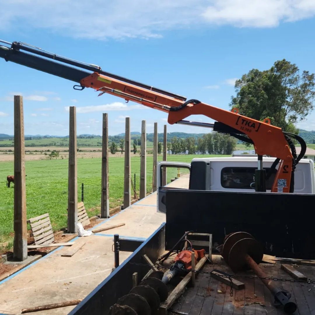 Guindaste articulado Munck TKA 12.700 instalado em caminhão, ideal para içamento e movimentação de cargas pesadas