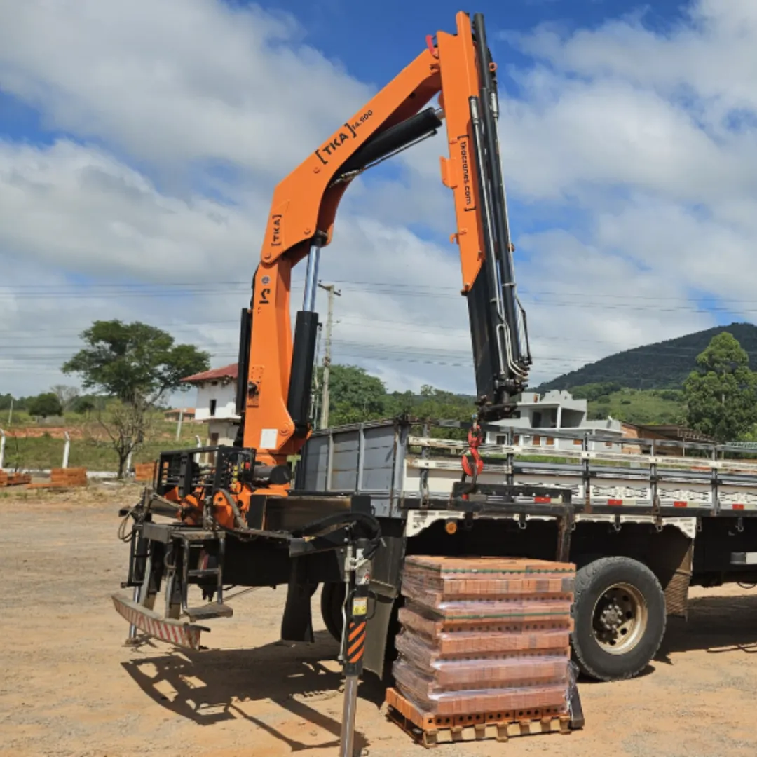 Guindaste articulado Munck TKA 14.900 instalado em caminhão levantando blocos