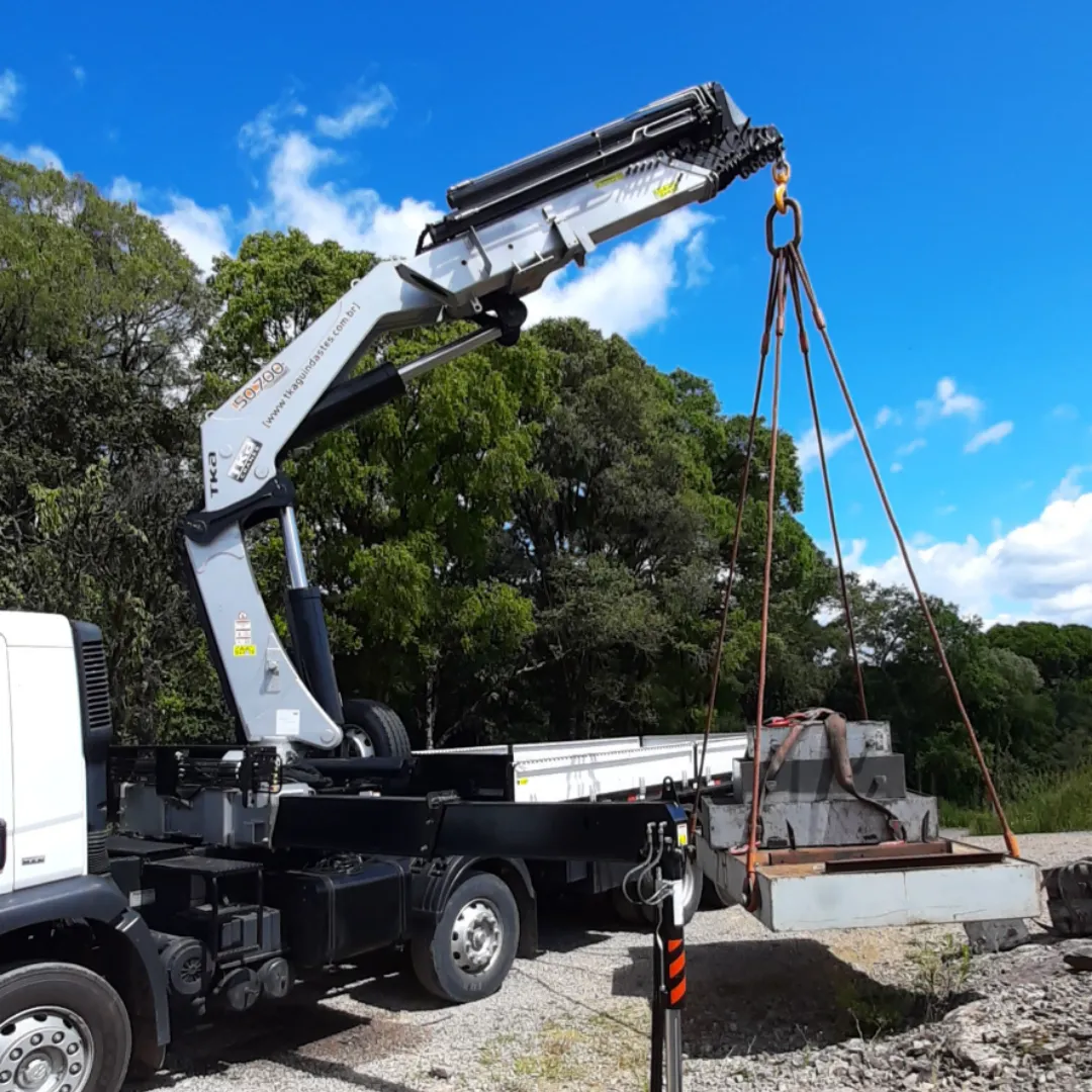 Guindaste articulado Munck TKA 48.700 instalado em caminhão içando carga