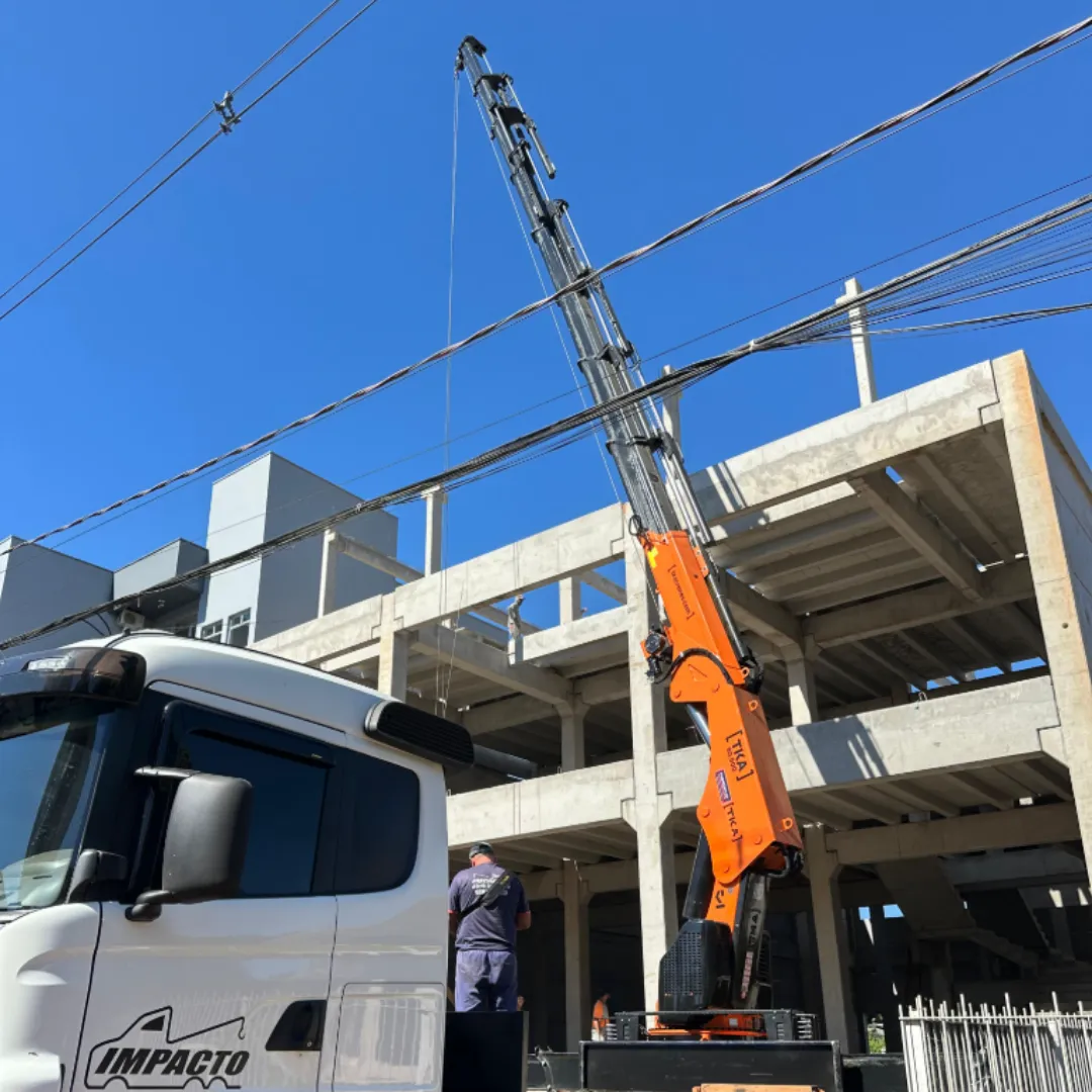 Guindaste articulado Munck TKA 90.900 instalado em caminhão içando carga
